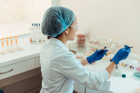 Biochemical analysis. Pleasant intelligent woman conducting a biochemical analysis while working in...
