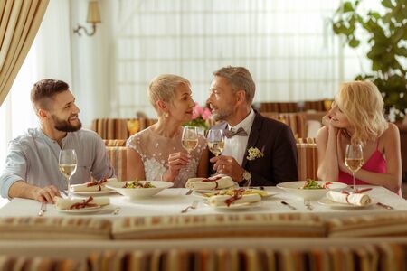 Celebrating wedding. Couple of mature aged man and woman celebrating wedding with childrenの写真素材