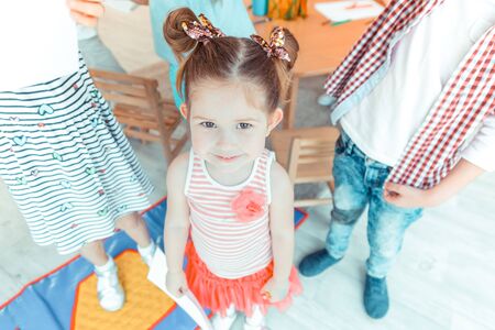 Beautiful smile. Top view of a pretty smiling girl while standing with her drawingの写真素材