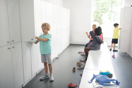 Getting ready. School children in a changing room preparing for their sports lesson.の写真素材