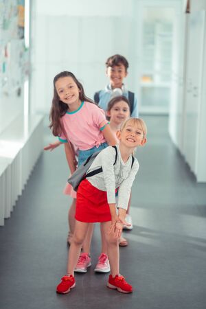Funny school break. Beautiful stylish girls and one handsome boy having fun during school breakの写真素材