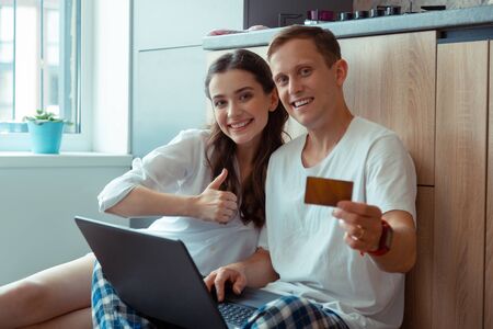 Processing online payment. Couple feeling good after processing online payment while shopping online