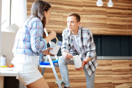 Talking about renovation. Couple eating delicious noodles and talking about renovation in their new houseの写真素材