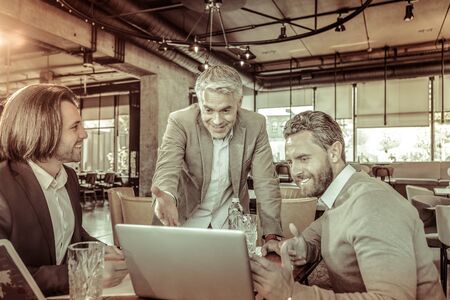 Friendly atmosphere. Group of joyful men that feeling happiness while being on business meetingの写真素材