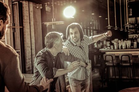 Do not fight. Angry man making fist while having quarrel in cafe