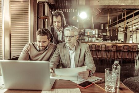 Waiting for feedback. Serious businessman pressing lips while being deep in thoughtsの写真素材