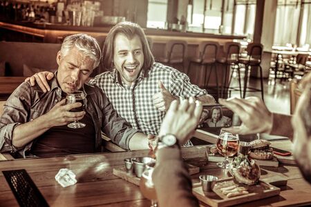 Drunk male keeping eyes closed while feeling tirednessの写真素材