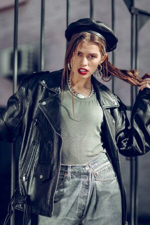 Stylish magazine. Skinny good-looking lady wearing bunch of bulky accessories while posing for...