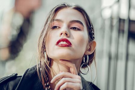 Confident and resolute. Nice-looking young photo model presenting bright red lipstick an new...