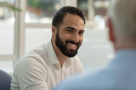 Business partners. Pleased bearded office worker expressing positivity while presenting his new ideaの写真素材