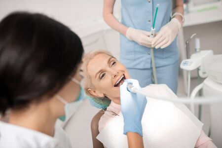 Happy being healthy. Cheerful woman being happy in dental clinic finally healing her teeth.の写真素材