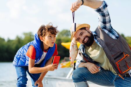 Son feeling surprised. Son feeling surprised and excited while seeing fish caught by father