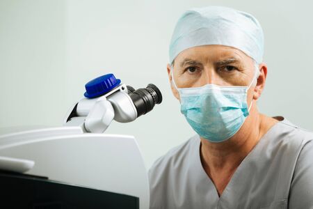 Experienced ophthalmologist. Smart hard working doctor looking at you while being at work in the...