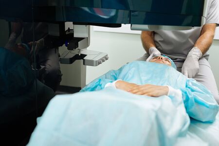 Caring about health. Nice adult woman waiting for her eyes to be checked while visiting a doctor