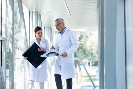 My assistant. Kind bearded professor wearing glasses while looking at analysis resultsの写真素材