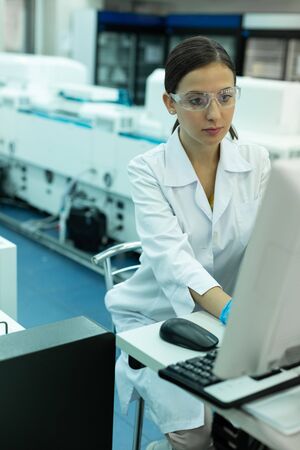 So serious. Attentive young researcher working at computer and doing technical analysisの写真素材