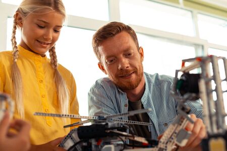 Model testing. Enthusiastic teacher building different complicated constructions during the science lesson with his pupils.の写真素材