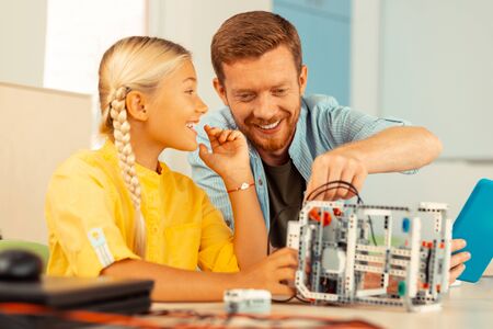 Impressed with science. Cheerful elementary schoolgirl sharing her impressions with the teacher during their science class.の写真素材