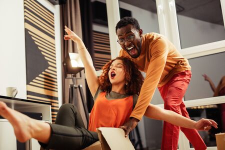 Time to rest. Happy young man demonstrating his gladness while joking with his girlfriend