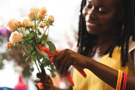 Best workplace. Close up of kind woman that using scissors while preparing flowers for ikebanaの写真素材