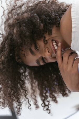 Good-looking female smiling putting a finger to her mouthの写真素材