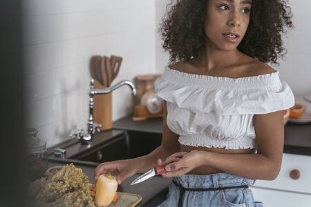 Beautiful young female being ready to chop vegetables
