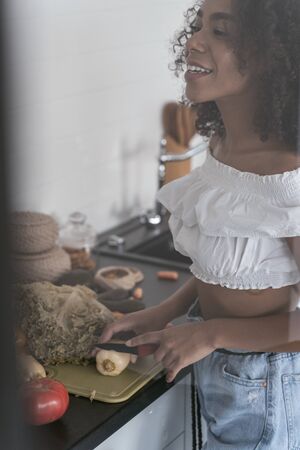 Beautiful female smiling and chopping vegetables for dinnerの写真素材