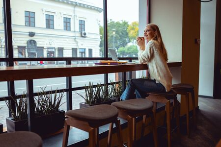 Lovely joyous woman in casual dress relaxing in a local cafeの写真素材