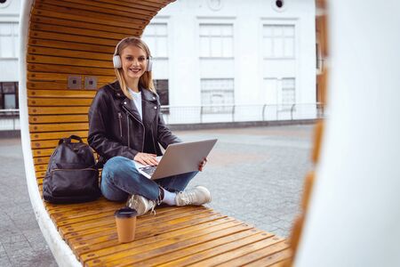 Cheerful female teleworker using free wifi network outdoors