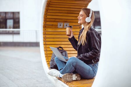 Beautiful young Caucasian female relaxing on an urban benchの写真素材