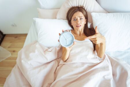 Early morning. Emotional girl wrinkling her forehead and looking straight at camera