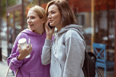 Here we are. Cute female person keeping smile on her face while talking per telephone