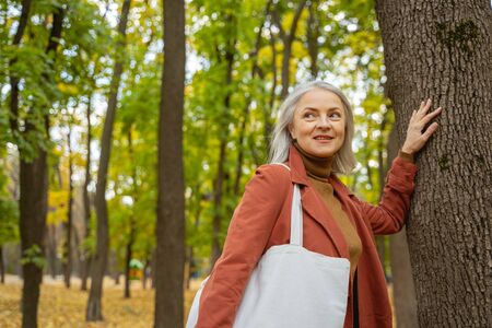 Waist-up portrait of a smiling female looking awayの写真素材