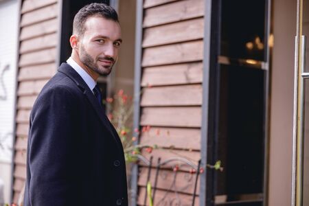 Watching you. Positive delighted man standing in semi position and turning head to camera