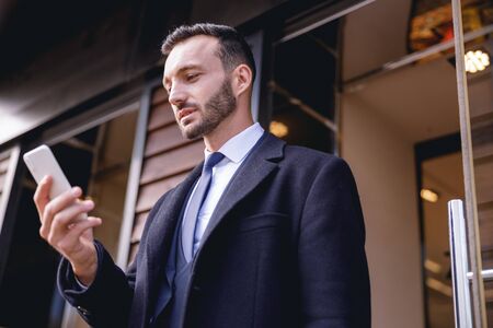 Income message. Kind bearded male concentrating his glance while reading emailsの写真素材