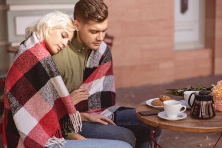 Pretty young female putting head on the shoulder of manの写真素材