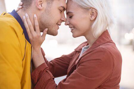 Close up picture of a loving couple going to kiss in the street
