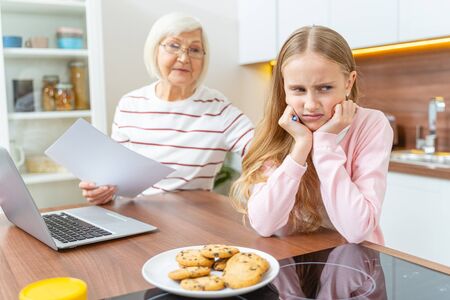 Dispirited girl sitting with her back to her grandmother