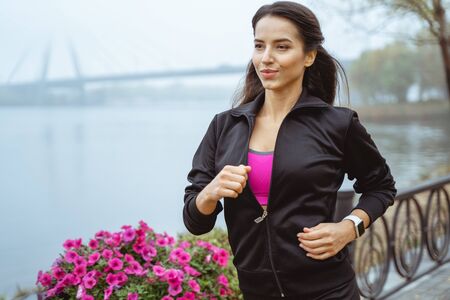 Keep fit. Beautiful female person looking forward while being in motionの写真素材