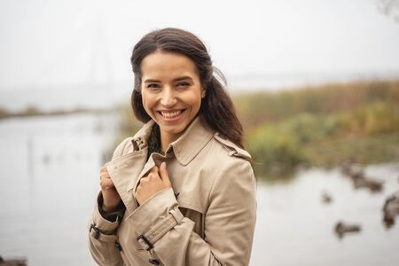 Feeling happiness. Delighted female person demonstrating her smile while enjoying relaxed walkの写真素材