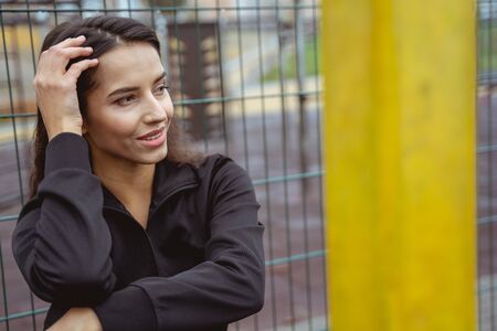 Cheerful brunette girl keeping smile on her face while thinking about next trainingの写真素材
