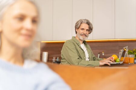 Serious male working at the table in the kitchenの写真素材