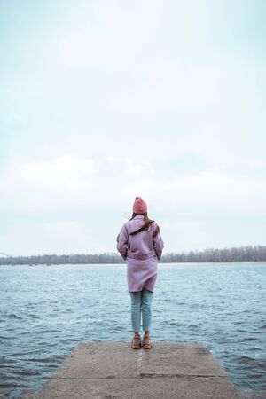 Kind girl looking at the river while enjoying sounds of waterの写真素材