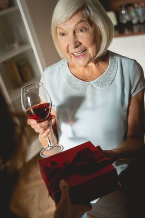 With love. Pleased blonde demonstrating her smile while looking at her granddaughterの写真素材