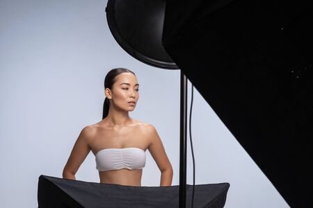 Young girl in white top posing for camera in studio. Female beauty conceptの写真素材