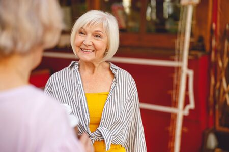 Good-looking aged female looking at her mate and smiling