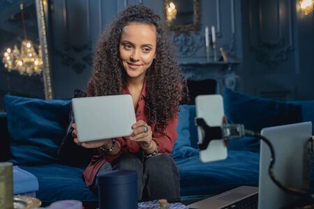 Smiling girl holding a tablet computer in front of the camera