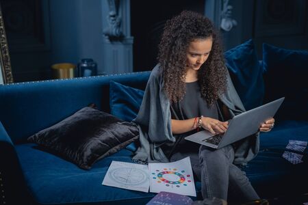 Serious modern lady focusing her attention on a laptop