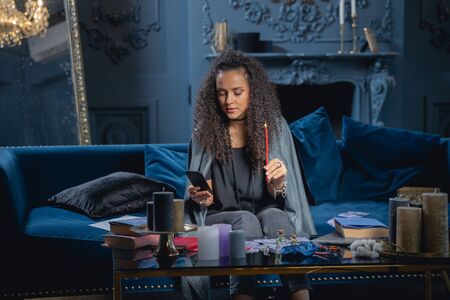 Young lady with a candle sitting on a couch