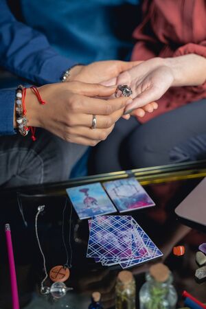 Cropped photo of a fortune-teller holding her clients hand